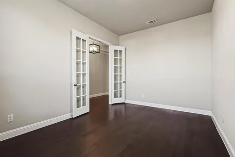 an empty room with wooden floor and closet