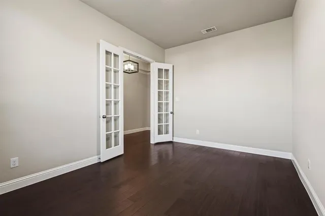 an empty room with wooden floor and closet