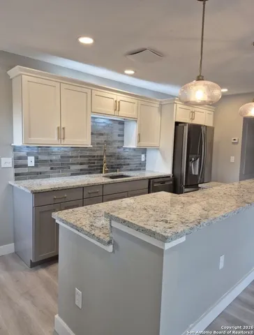 a kitchen with stainless steel appliances granite countertop a sink a stove and a refrigerator