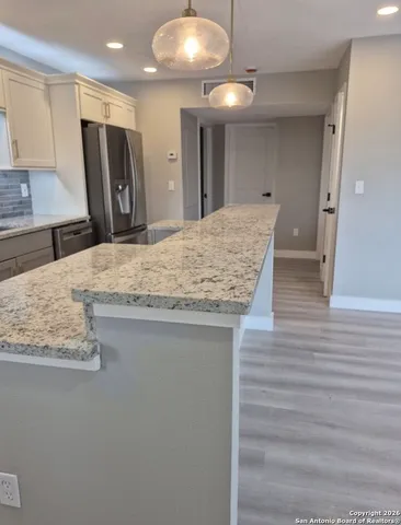 a bathroom with a granite countertop sink a toilet and mirror
