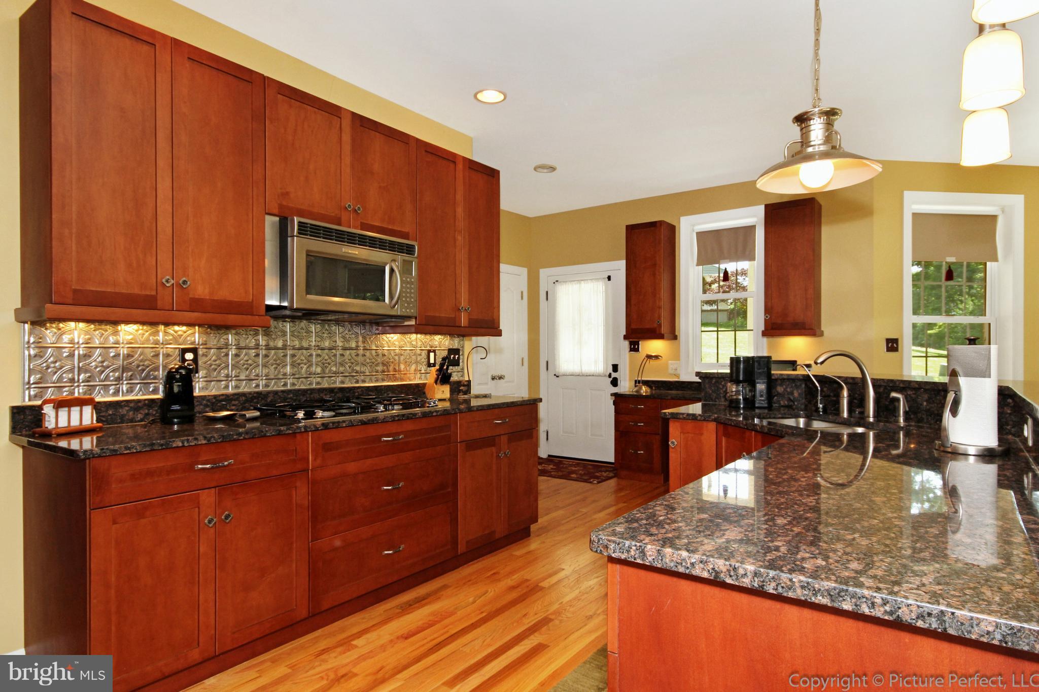 3063 Hooper Road New Windsor, MD 21776 - Photo 8 of 25 a kitchen with sink a stove and chairs
