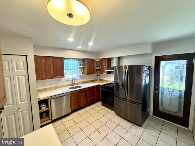 a kitchen with stainless steel appliances granite countertop a refrigerator and a sink