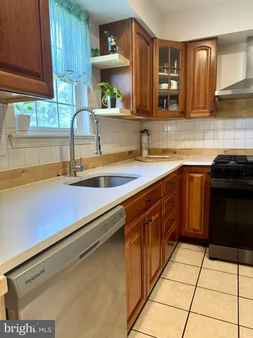 a kitchen with stainless steel appliances a sink stove and cabinets