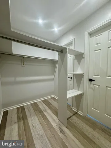 a room with walk in closet and wooden floor