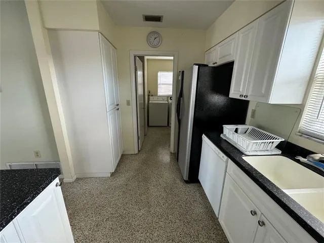 a kitchen with granite countertop a stove sink and microwave