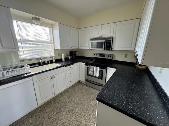 a kitchen with a refrigerator stove and sink