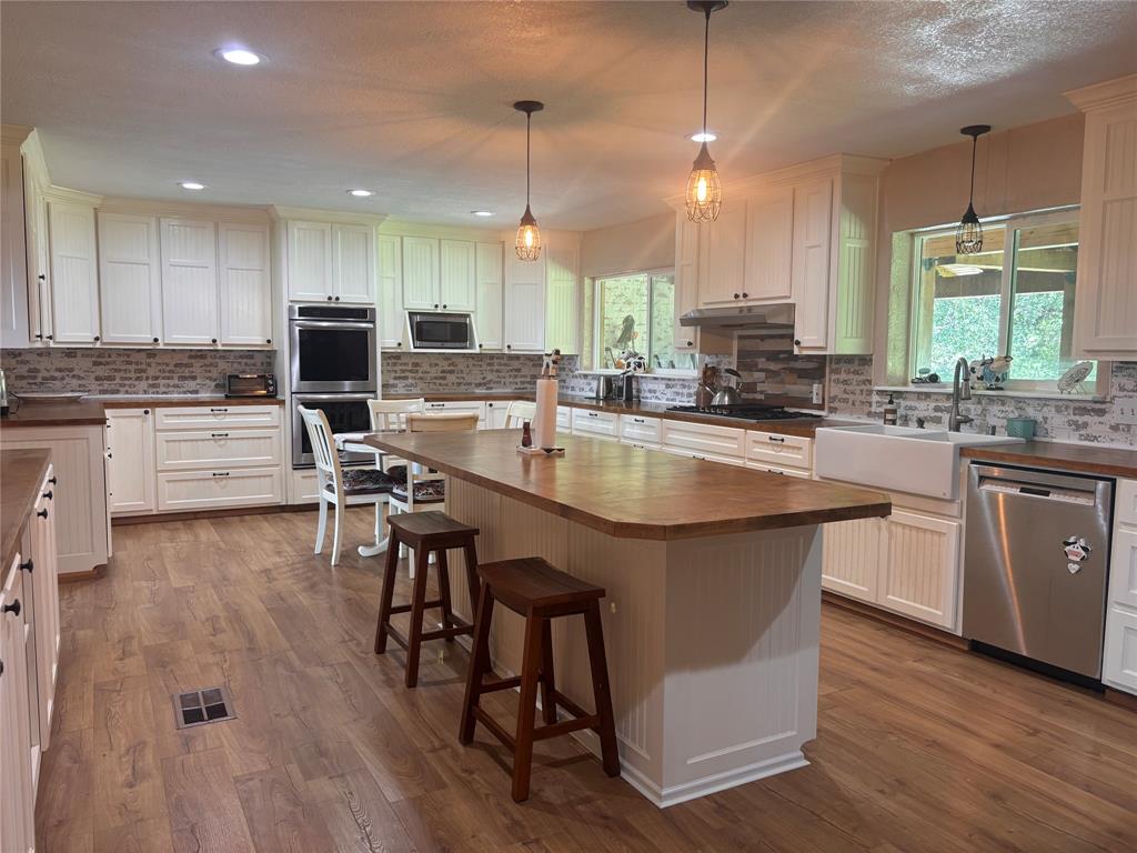 5355 Banks Road Fort Worth, TX 76140 - Photo 11 of 29 a kitchen with stainless steel appliances granite countertop a stove top oven a sink dishwasher a dining table and chairs with wooden floor
