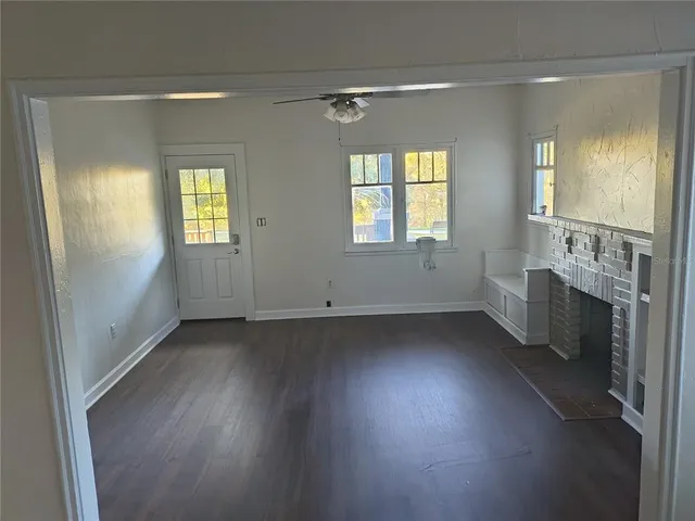 an empty room with windows and fireplace