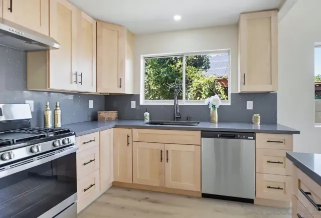 a kitchen with cabinets appliances and a window