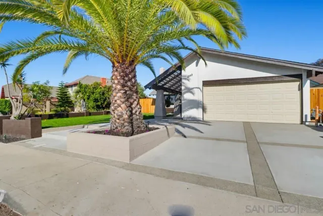 a view of a house with a yard and potted plants
