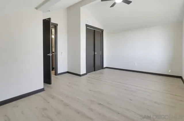 an empty room with closet and windows