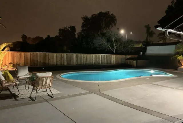 a view of a chairs and table in the backyard