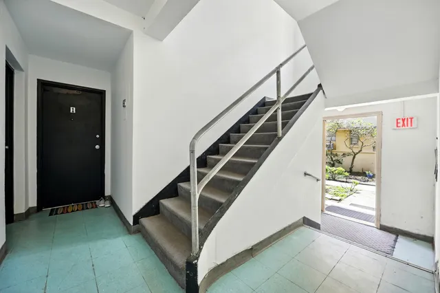 a kitchen with granite countertop a refrigerator and a stove top oven