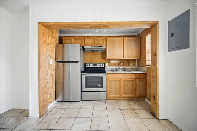 an empty room with a ceiling fan and carpet