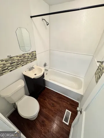 a bathroom with a toilet a sink and a mirror