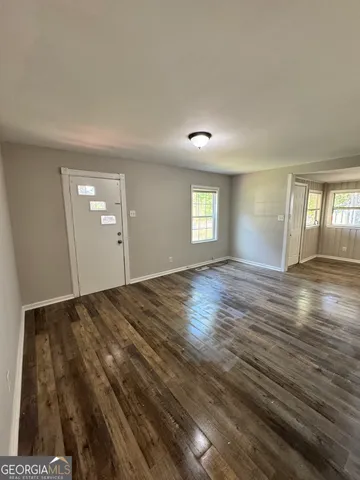 a view of an empty room and window and wooden floor