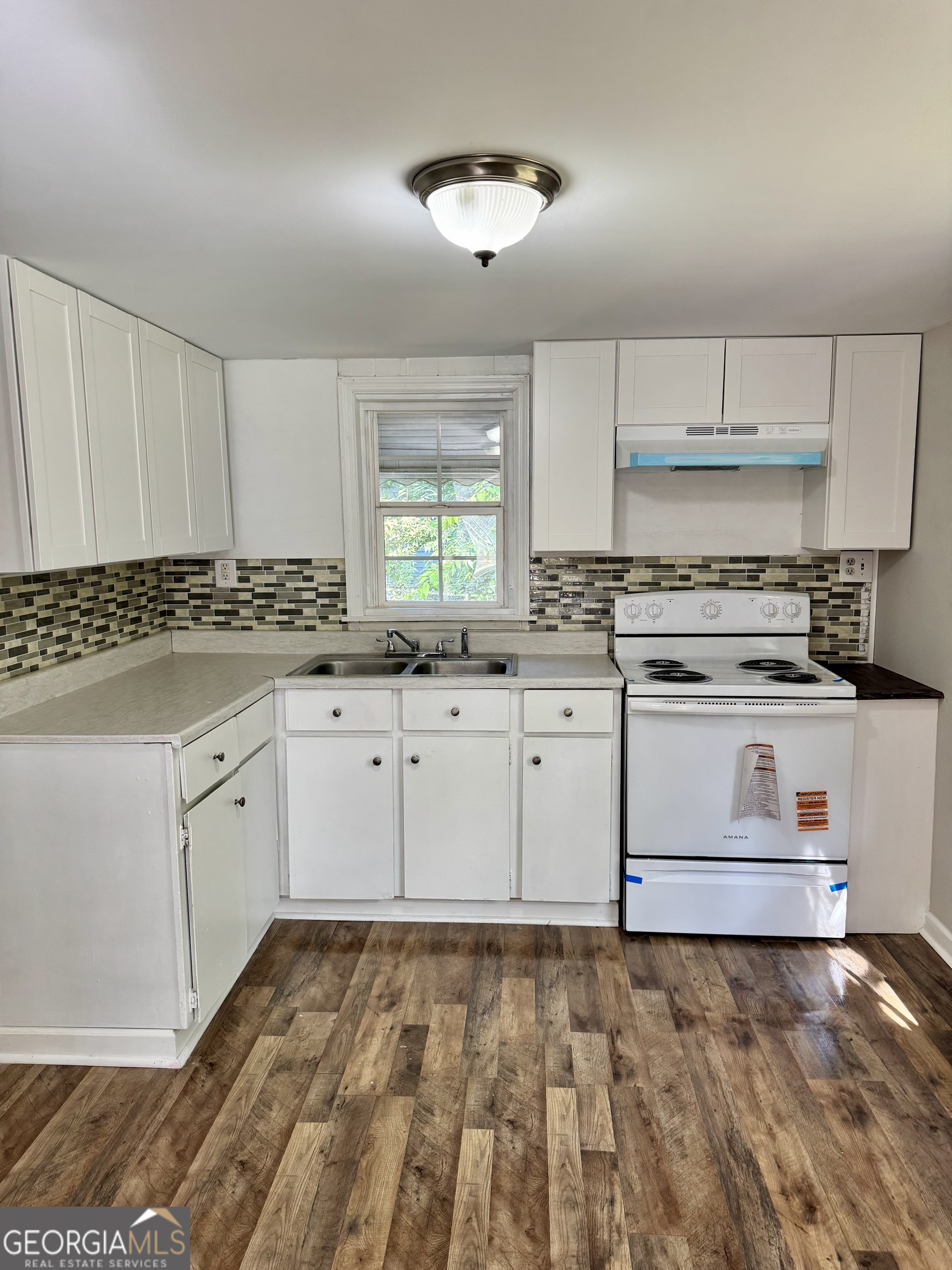 1282 Hartley Street Macon, GA 31206 - Photo 7 of 15 a kitchen with granite countertop a stove sink and cabinets