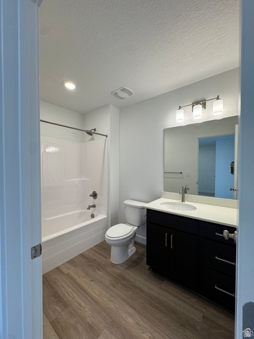 1883 West 1575th North, Unit 236 Layton, UT 84041 - Photo 14 of 22 Full bathroom featuring dark wood finished floors, vanity, bathtub / shower combination, and a textured ceiling