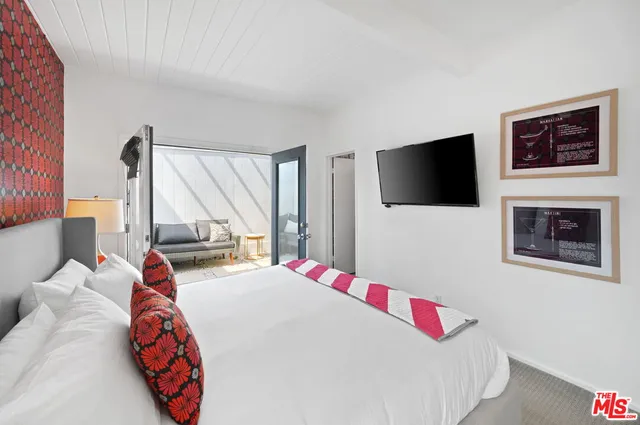 a bedroom with a bed and a flat screen tv