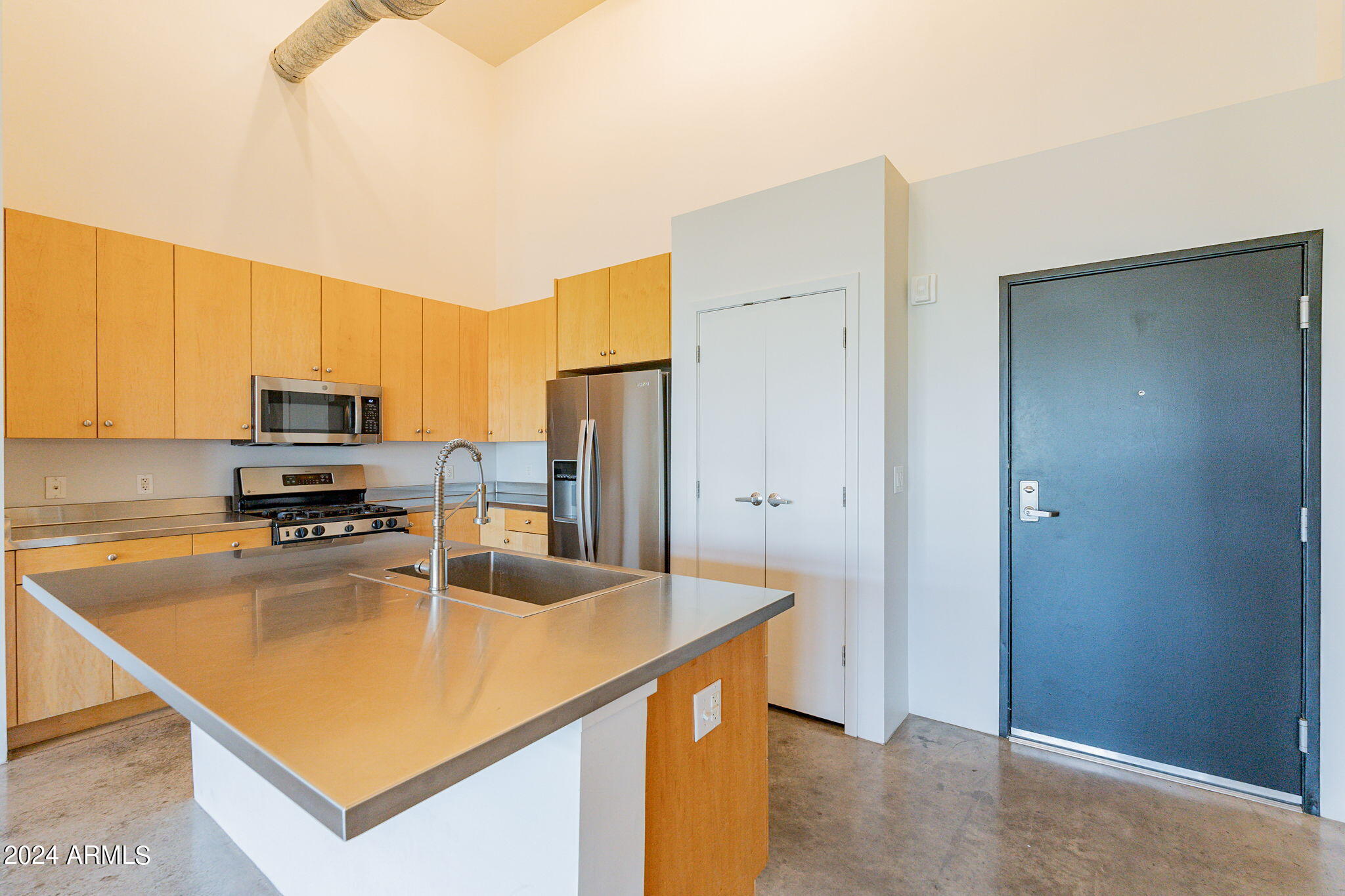 914 East Osborn Road, Unit 416 Phoenix, AZ 85014 - Photo 17 of 44 a kitchen with stainless steel appliances granite countertop a refrigerator a stove and a sink with wooden floor