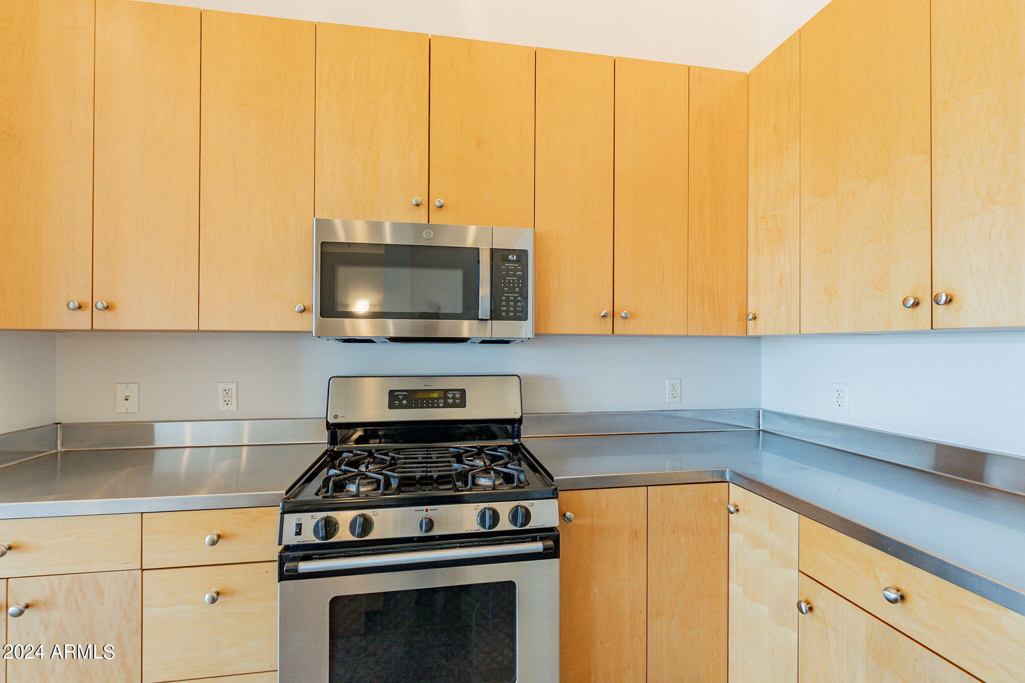 914 East Osborn Road, Unit 416 Phoenix, AZ 85014 - Photo 20 of 44 a kitchen with stainless steel appliances granite countertop a stove a microwave and cabinets