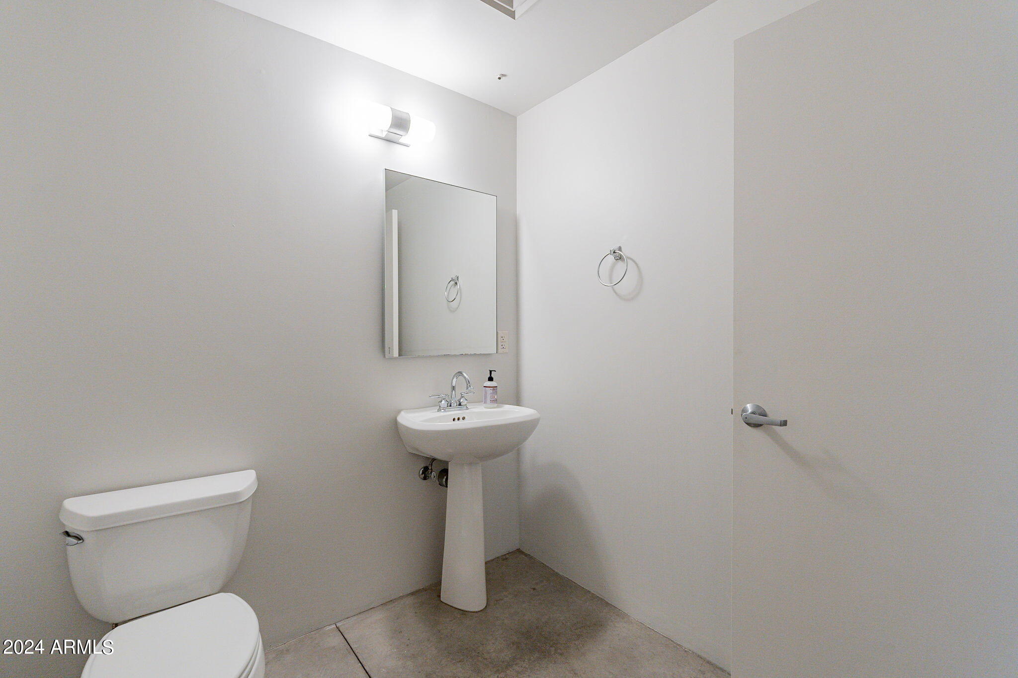 914 East Osborn Road, Unit 416 Phoenix, AZ 85014 - Photo 23 of 44 a bathroom with a toilet sink and mirror