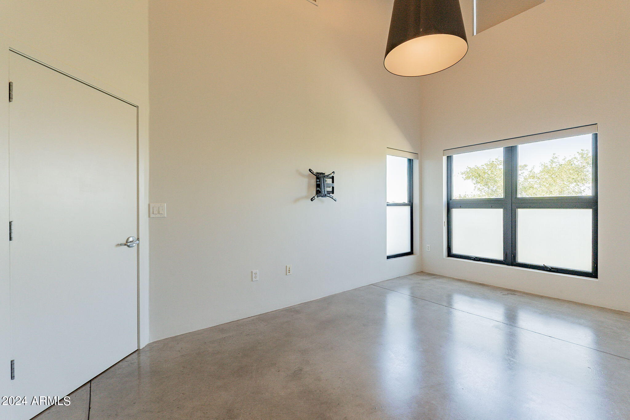 914 East Osborn Road, Unit 416 Phoenix, AZ 85014 - Photo 26 of 44 a view of an empty room with a window and wooden floor