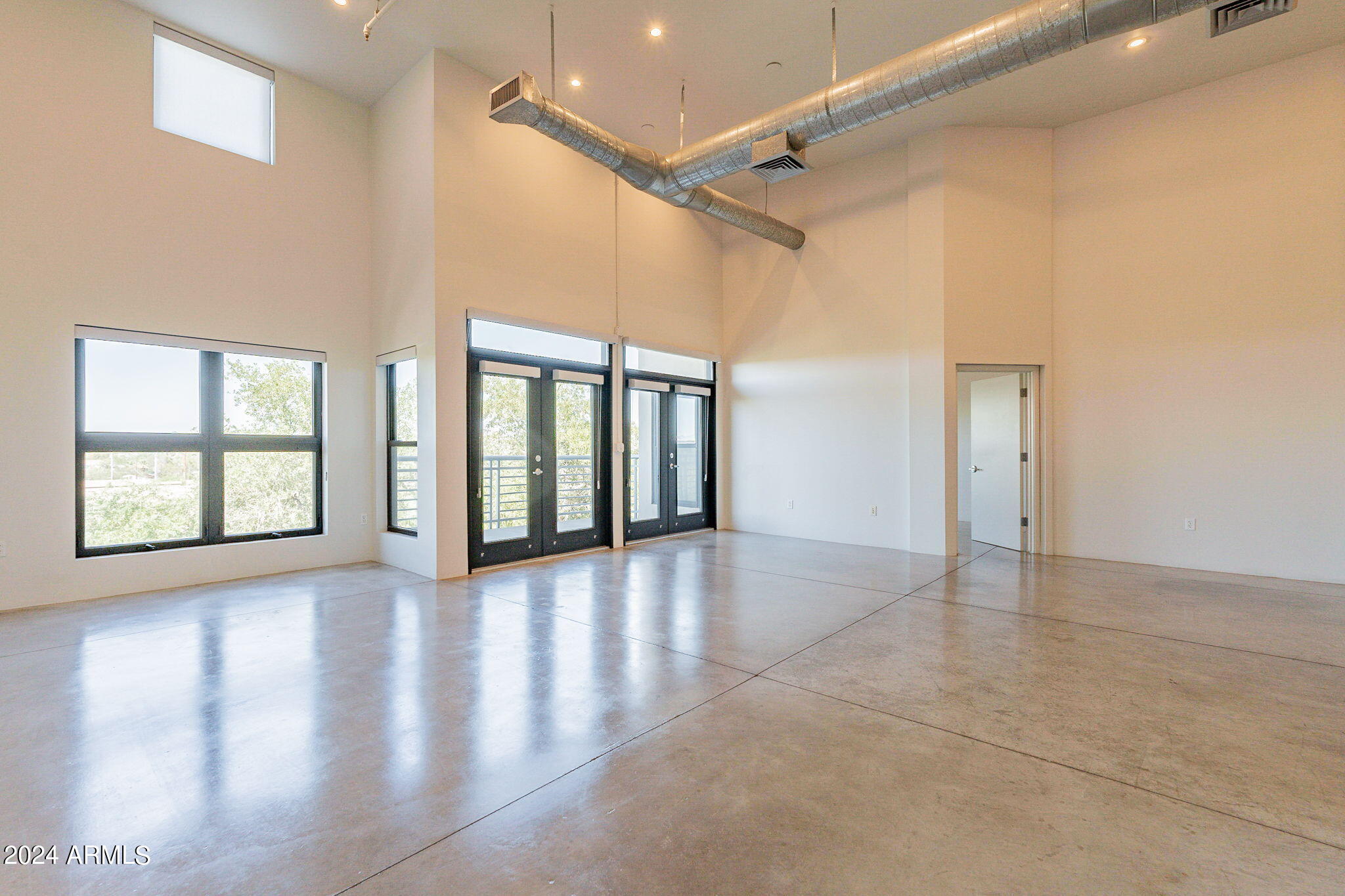 914 East Osborn Road, Unit 416 Phoenix, AZ 85014 - Photo 8 of 44 a view of an empty room with a window and wooden floor