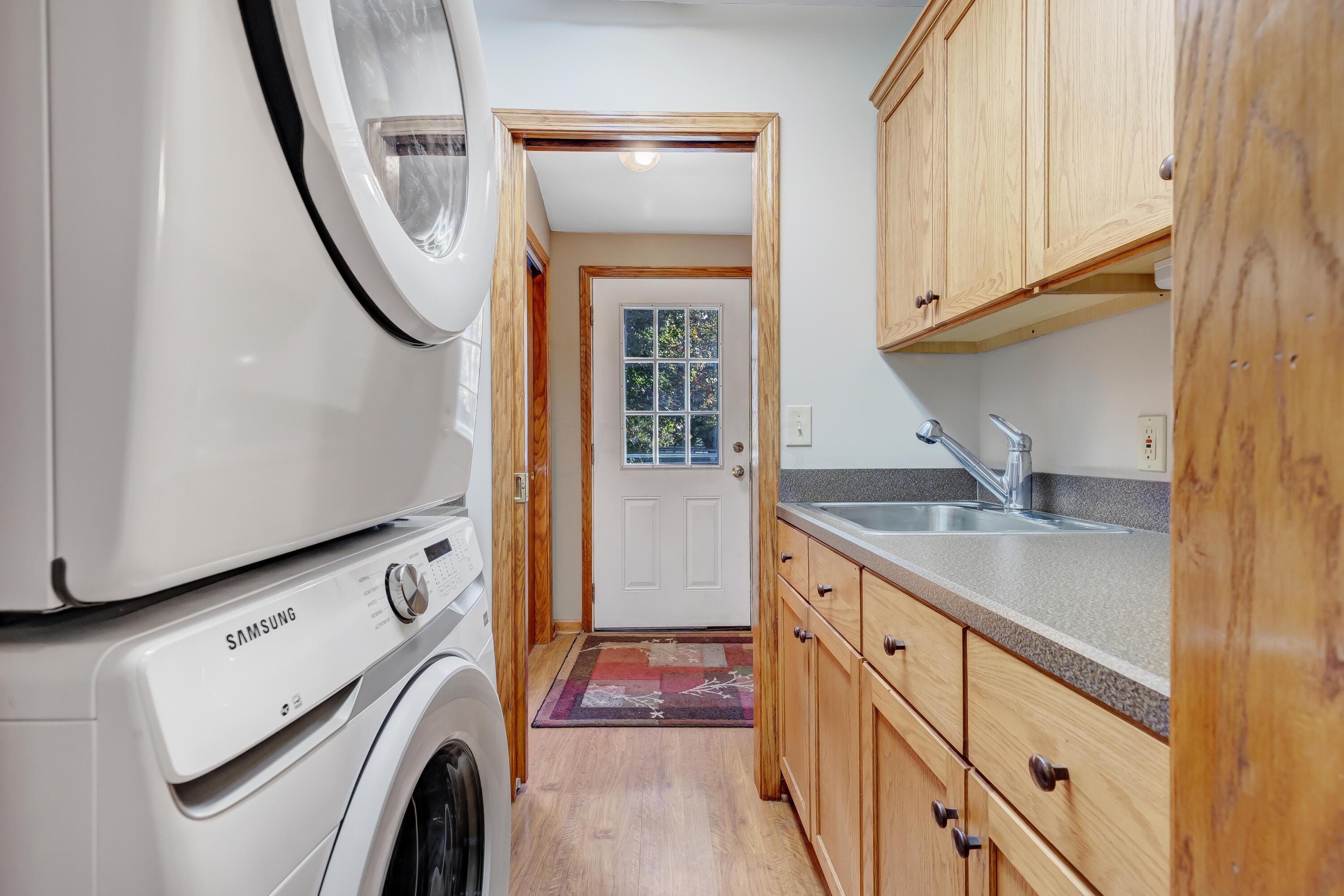 6681 Harlem Road Westerville, OH 43082 - Photo 25 of 78 • Laminate flooring • Ivory painted walls • Wall cabinets & countertop • Ceiling Light • Enclosed utility sink • New washer and dryer ~ 2022 remain • Pocket door to rear entry & hall