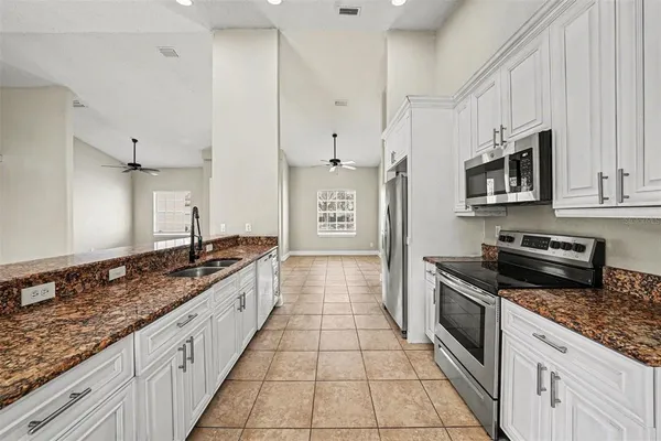 a large kitchen with stainless steel appliances granite countertop a stove a sink and a granite counter tops