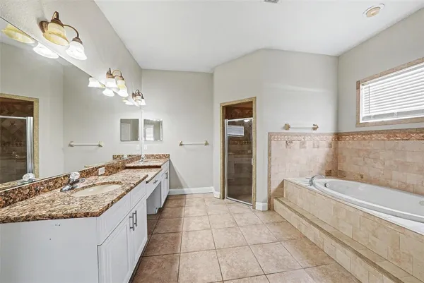 a spacious bathroom with a granite countertop sink a toilet a mirror and shower