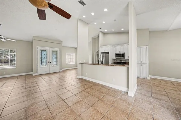 a view of a kitchen with refrigerator and white cabinets