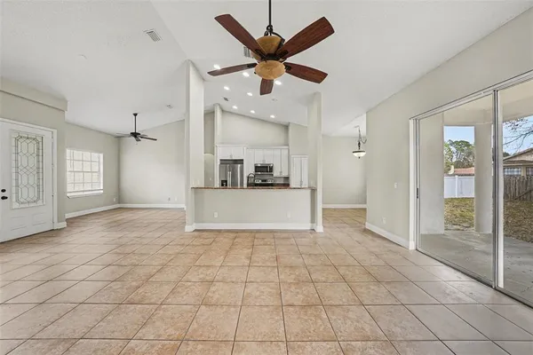 a view of an empty room with cabinet and a ceiling fan