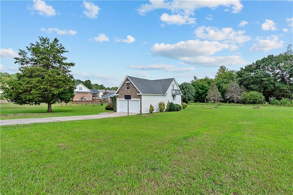 7 Herchel Mize Road Southwest Cave Spring, GA 30124 - Photo 2 of 58 a white house with a big yard and large trees