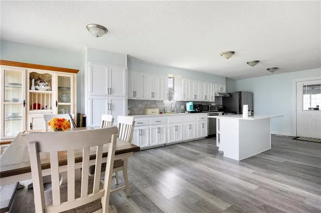 a kitchen with stainless steel appliances granite countertop a stove a sink and white cabinets