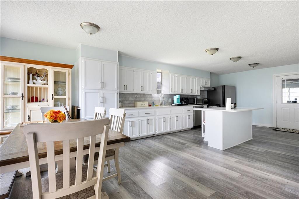 7 Herchel Mize Road Southwest Cave Spring, GA 30124 - Photo 27 of 58 a kitchen with stainless steel appliances kitchen island wooden floors and white cabinets