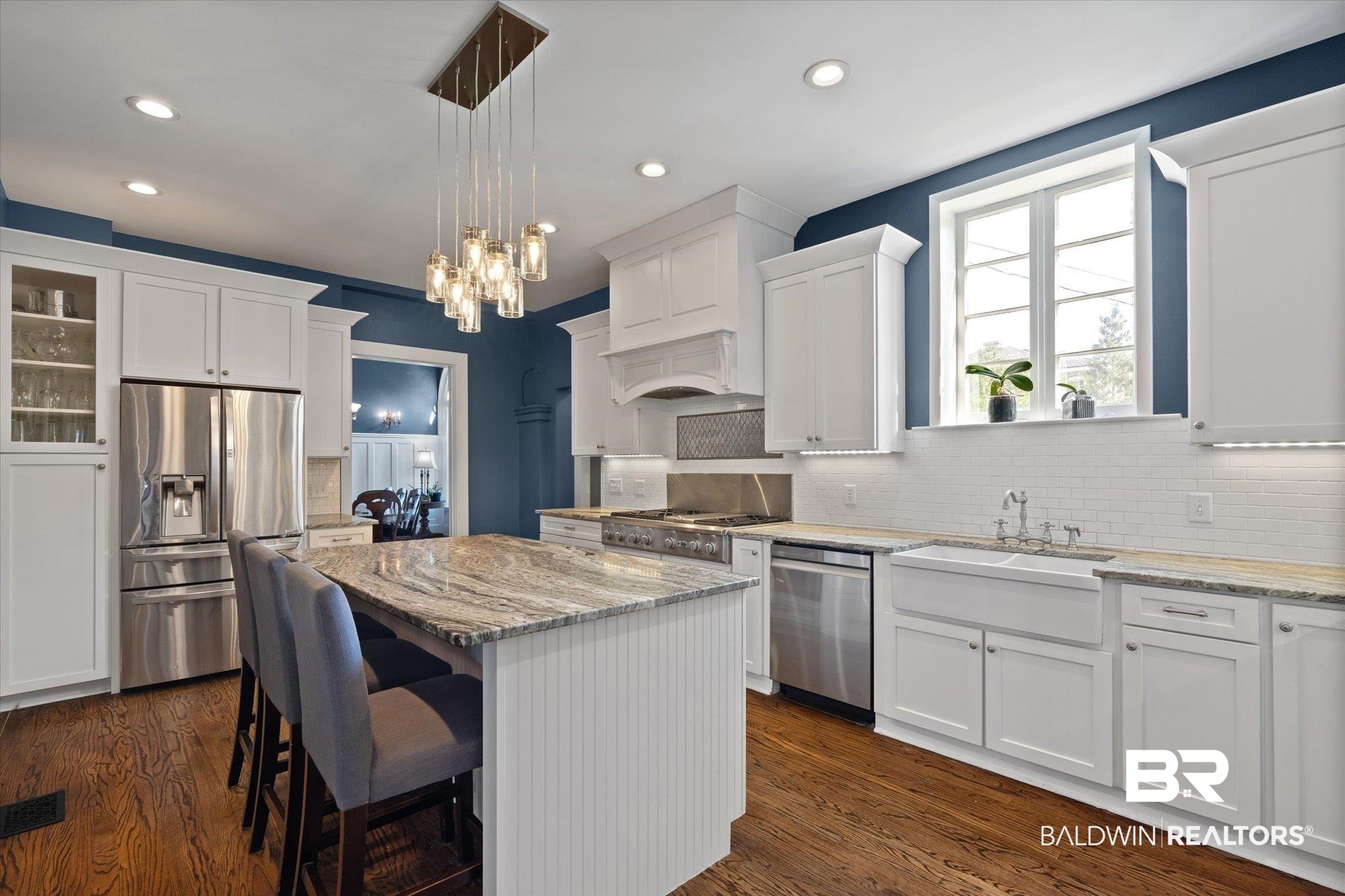 1953 Dauphin Street Mobile, AL 36606 - Photo 13 of 56 Kitchen with stainless steel appliances, dark hardwood / wood-style flooring, white cabinets, a kitchen island, and pendant lighting