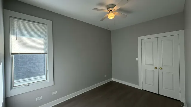 an empty room with a window and a fan
