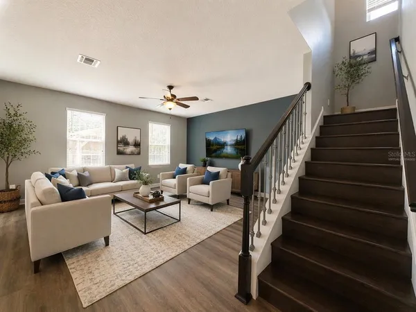 a living room with furniture and wooden floor
