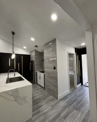 a kitchen with stainless steel appliances kitchen island granite countertop a refrigerator and a sink