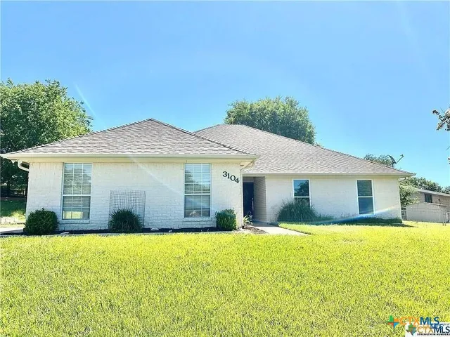 a front view of a house with yard and glass windows