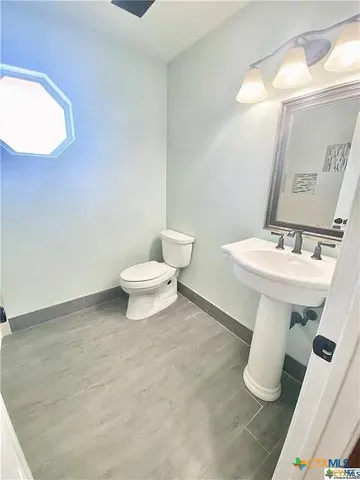 a bathroom with a sink toilet and mirror
