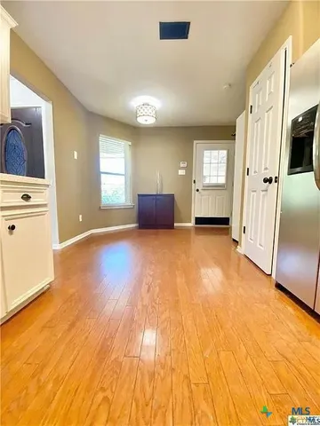 a view of a big room with wooden floor and windows