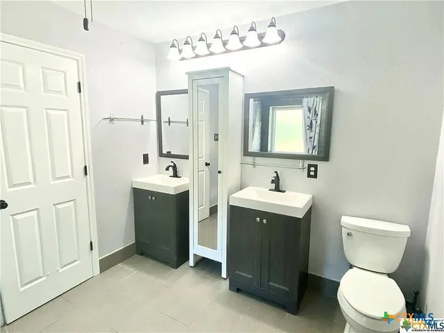 a bathroom with a toilet sink and mirror