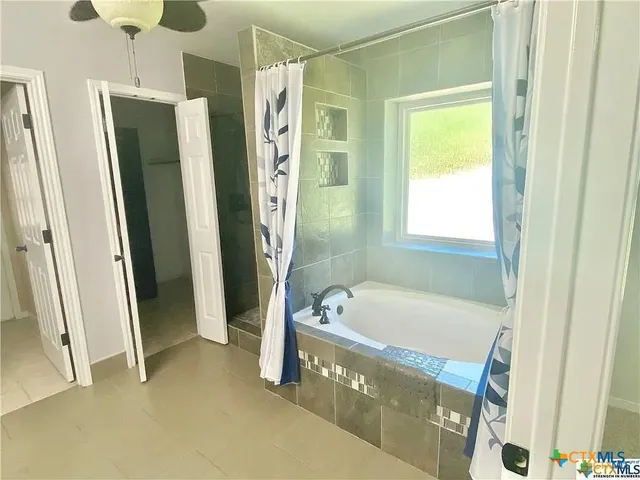 a bathroom with a tub a sink and a shower