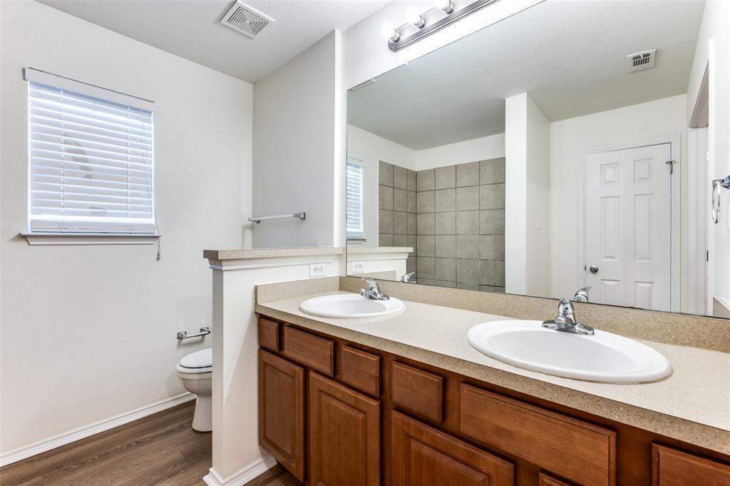 1012 Barbara Street Denton, TX 76209 - Photo 14 of 23 a bathroom with a sink double vanity and a toilet