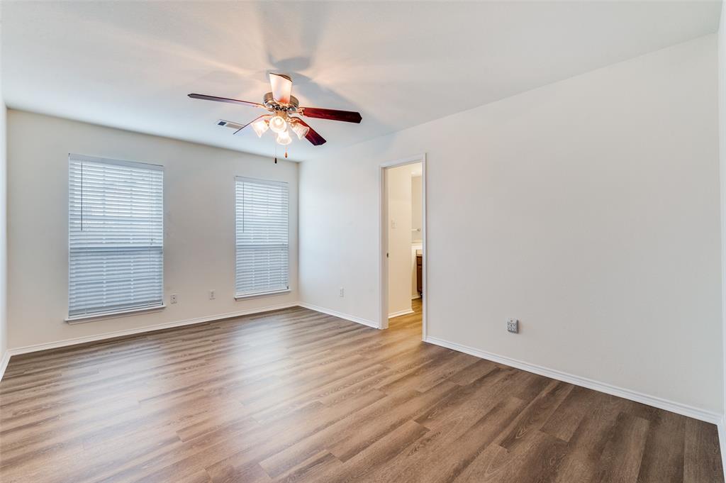 1012 Barbara Street Denton, TX 76209 - Photo 15 of 23 an empty room with wooden floor ceiling fan and windows