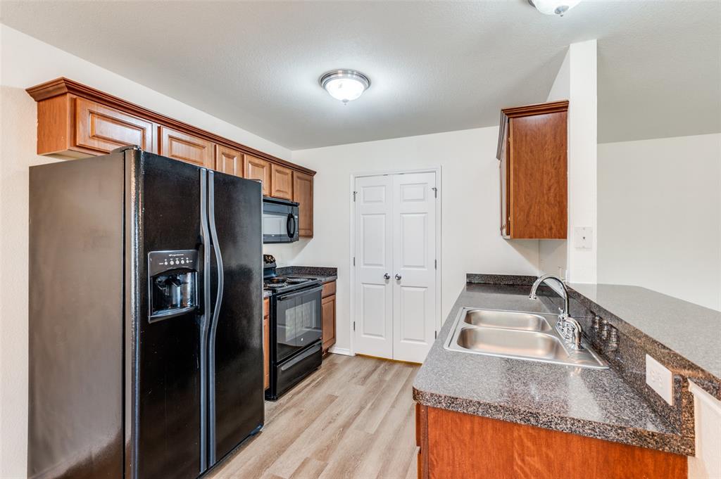 1012 Barbara Street Denton, TX 76209 - Photo 7 of 23 a kitchen with stainless steel appliances granite countertop a refrigerator and a sink