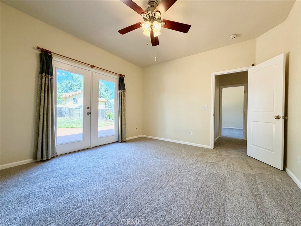 1037 Mark Twain Road Angels Camp, CA 95222 - Photo 28 of 52 an empty room with chandelier fan and windows