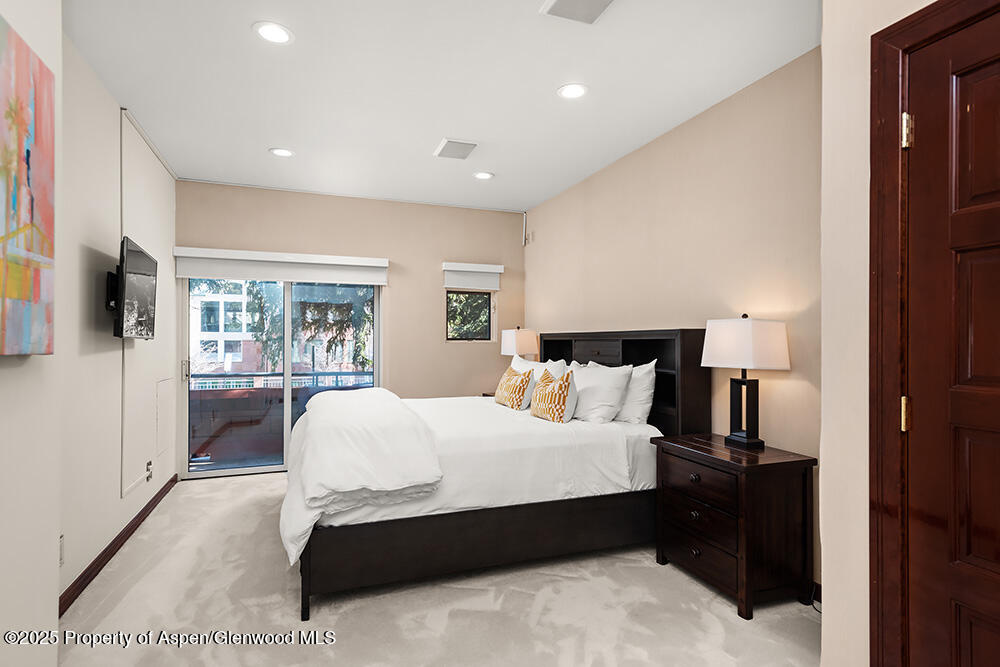 208 South Spring Street, Unit 1 Aspen, CO 81611 - Photo 16 of 29 a bedroom with a large bed and a large window